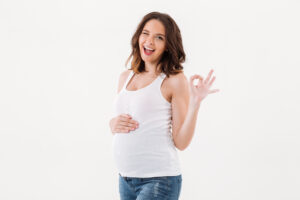 Cheerful Pregnant Woman Showing Okay Gesture.