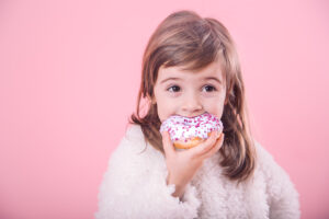 Portrait Of Cute Little Girl With Donut